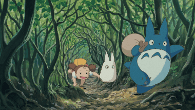 Mei chasing the medium-sized blue Totoro through a tunnel of grass.