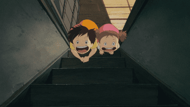 The sisters picking up an acorn in front of the dark stairs and shouting 'Come out, soot sprites!'