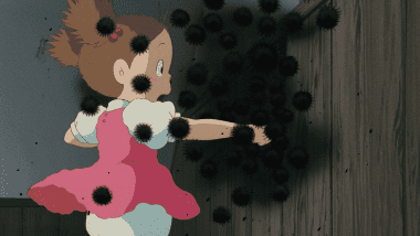 Mei poking her finger into a crack in the attic, peering at the fleeing soot sprites (Susuwatari).