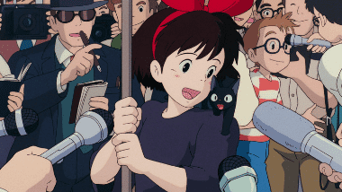 Kiki being interviewed with Jiji on her shoulder after rescuing Tombo