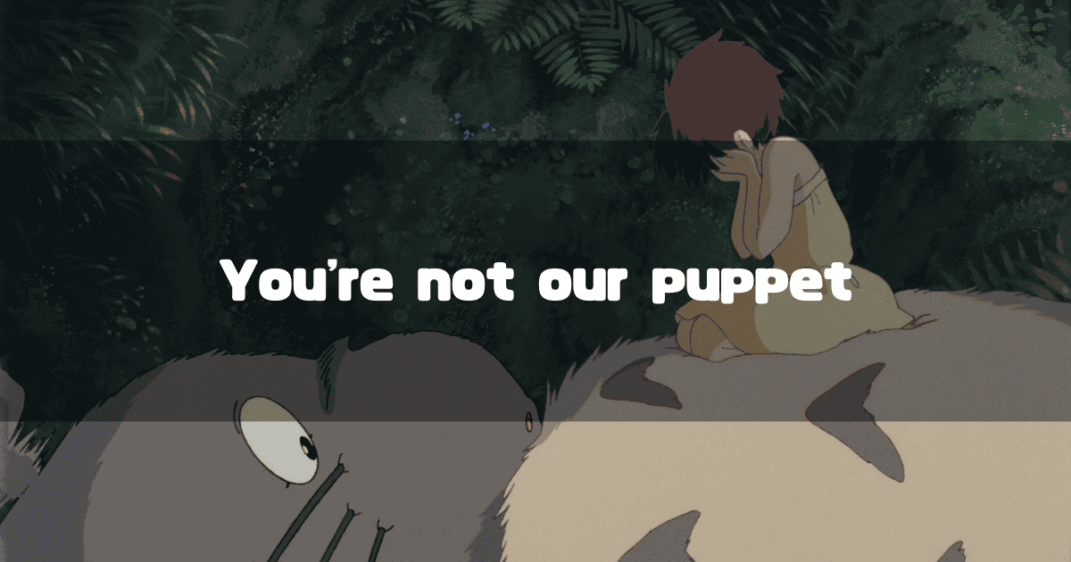 An anime still from "My Neighbor Totoro" showing the character Mei sitting sadly on Totoro's large belly in a forest. The text overlay reads: "You're not our puppet."