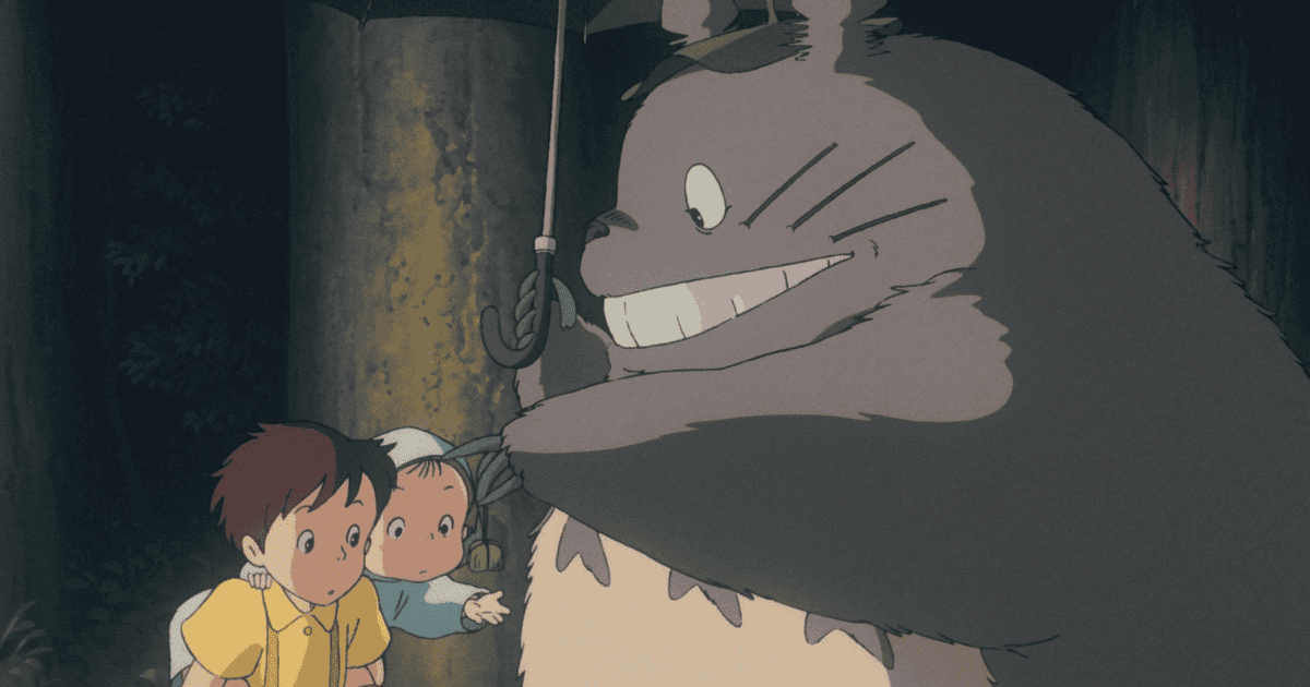 Totoro holding an umbrella beside two children at a rainy forest bus stop
