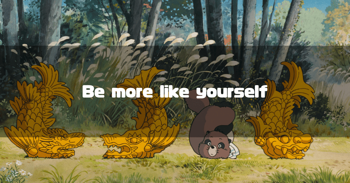 In a scene from "Pom Poko," a tanuki looks flustered mid-transformation while others beside it have successfully become golden Shachihoko statues, with the text "Be more like yourself" written in the center.