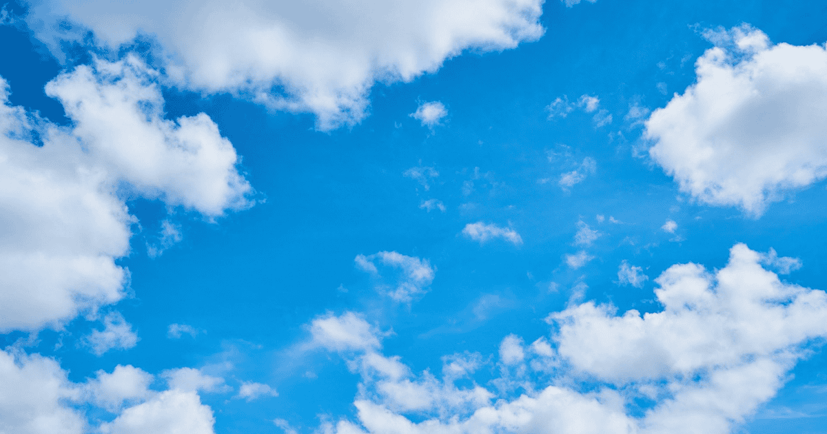 Bright blue sky filled with soft white clouds on a clear summer day